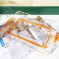Moderne minimalistische transparente Acryl-Servierplatte mit leuchtendem orangefarbenem Rand. - Orange