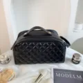 Borsa da trucco trapuntata nera da viaggio con manico e cerniera. Organizzatore cosmetico chic. - Nero