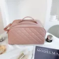 Dettaglio della borsa per cosmetici trapuntata rosa, pelle morbida e doppia cerniera robusta. - Rosa