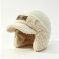 Gros plan détaillé du bonnet en peluche crème douce avec élégant patch en cuir marron. - Beige
