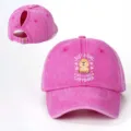 Detailansicht der rosa gewaschenen Pferdeschwanz-Baseballkappe mit Capybara-Grafik. - Fuchsia