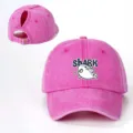 Primo piano del cappello da baseball rosa con coda di cavallo, grafico di squalo e cinturino. - Regolabile / Rosso rosa