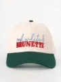 Detail view of a color-block baseball cap with embroidered lettering on the front, adjustable fit. - Adjustable / Beige and Dark Green
