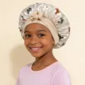 Detailed view of children's satin butterfly print sleep cap with elastic strap for hair care. - Beige