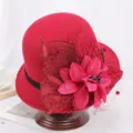 Vue détaillée de l'élégant chapeau cloche en laine rouge avec grande fleur et voile en filet. - M (56-58cm) / Fleur de Dentelle / Bordeaux