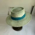 Mint green straw hat detail showcasing fine weaving and a chic dark teal ribbon decoration. - M (56-58cm) / Cyan
