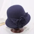 Gedetailleerd overzicht van donkerblauwe wolvilt cloche hoed met elegante stoffen bloem- en bladversiering. - M (56-58cm) / Pioenroos Donkerblauw