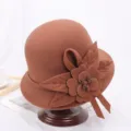 Gedetailleerde close-up van de elegante bruine viltkoepelhoed met bloembladdecoratie. - M (56-58cm) / Kwast Karamel