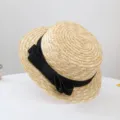 Close-up detail of a classic flat top straw sun hat featuring an elegant black bow ribbon. - 50-52cm (Recommended 2-6 Years) / Black