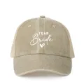 Detailed view of the distressed khaki trucker hat featuring white team bride print and mesh. - Adjustable / Khaki