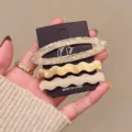Detail view of 3-piece acetate hair clip set featuring elegant wavy and oval cutout designs. - Beige Tie-Dye Hair Clip 3-Piece Set (Acetate)