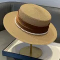 Vue rapprochée du chapeau de paille élégant avec ruban marron et bordure de perles délicate. - Réglable / Kaki