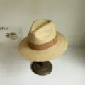 Nahaufnahme des handgeflochtenen Bast-Sonnenhutes mit braunem Band für Sommeroutfits. - M (56-58cm) / Mokkabraunes Band