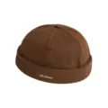Nahaufnahme der braunen Baumwoll-Docker-Mütze im Retro-Stil mit feinem gestickten Textaufnäher. - M (56-58cm) / Kaffeebraun