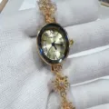 Close-up of the gold oval quartz watch dial with crystal bezel and snowflake bracelet links. - Gold Gold Face