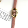 Gros plan sur une montre quartz femme style vintage bracelet cuir rose et boîtier ovale doré. - Boîtier Doré Cadran Rose Bracelet Rose
