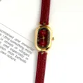 Detail view of a vintage oval women quartz watch with red leather strap and red dial. - Gold Case Red Dial Red Strap