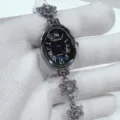 Detailed close-up view of the elegant oval quartz watch with delicate snowflake bracelet details. - Silver Case Black Dial
