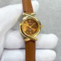 Close-up detail of women quartz watch, brown leather strap, gold cross case design. - Gold Case Coffee Dial Coffee Strap