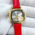 Detailed closeup view of red leather strap with gold square case quartz watch dial - Gold Case White Dial Red Strap