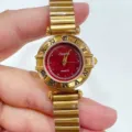 Reloj de cuarzo vintage dorado con esfera roja brillante y bisel números romanos detalle. - Caja Dorada Esfera Roja