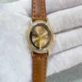 Élégante montre à quartz pour femme avec lunette ovale en strass et bracelet en cuir marron. - Boîtier Doré Cadran Café Bracelet Café
