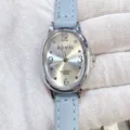 Nahaufnahme der kloris Damen Quarzuhr, silbernes ovales Zifferblatt mit blauem Lederarmband. - Silbernes Gehäuse Weißes Zifferblatt Hellblaues Armband