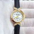 Gros plan de la montre pour femme avec connecteur X en strass et bracelet en cuir noir. - Boîtier Doré Cadran Blanc Bracelet Noir