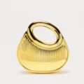 Close-up detail of luxury gold metallic acrylic evening clutch bag with ring handle and vertical stripes. - Gold