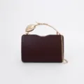 Detail shot of the dark red evening clutch with gold tulip metal handle and chic chain strap. - Burgundy