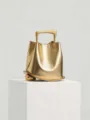 Luxury metallic gold bucket bag with unique sculptural handle and base for modern women. - Gold