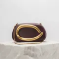 Elegant maroon clutch bag featuring an abstract gold-tone metal handle and chic chain strap. - Burgundy