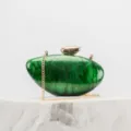 Green marble acrylic clutch purse detail showing gold chain strap and metal clasp closure. - Green
