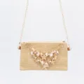 Detailed view of straw woven shoulder bag featuring gold chain, seashell and pearl decorations. - Envelope Shell