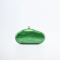 Green marble acrylic evening clutch detail showing smooth texture and pearl clasp. - Green