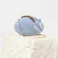 Detailed close-up of blue marble acrylic evening bag with gold leaf lock and chain strap. - Blue
