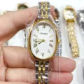 Vue détaillée de la montre quartz ovale pour femme avec cadran blanc et bracelet bicolore élégant. - Bicolore Cadran Blanc