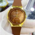 Détail d'une montre à quartz au cadran marron, boîtier doré et bracelet en silicone confortable au quotidien. - Cadran Café Bracelet Café (Hommes)