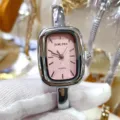 Closeup view of a square pink dial quartz bangle watch with polished silver metal strap. - Silver Case Pink Dial