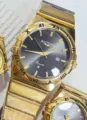 Golden quartz couple watch with dark dial, Roman numerals, calendar display, stylish design. - All Gold Black Dial Men