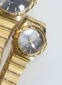 Gold quartz couple watch set with dark dial, Roman numerals, calendar and durable metal strap. - All Gold Black Dial Women