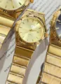 Gold quartz couple watch with Roman numerals, metal strap and calendar display for daily wear. - All Gold Gold Dial Women