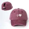 Detail view of the distressed ponytail baseball cap featuring a white heart ECG graphic. - Adjustable / Burgundy