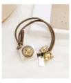 Cute vintage brown hair tie featuring a golden bear charm and classical coin pendant detail. - Gold Bear Tag