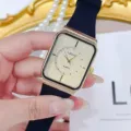Nahaufnahme Detail der Vintage Retro rechteckigen Quarzuhr mit goldenem Zifferblatt Armband. - Goldenes Zifferblatt Schwarzes Armband