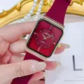 Nahaufnahme Detail der Vintage Stil quadratische Zifferblatt Quarzuhr mit burgunder Armband. - Rot