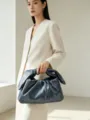 Detailed view of the dark grey gathered clutch bag held elegantly by a model indoors. - 23CM*7CM*12.5CM / Grey Blue
