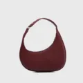 Detail view of the burgundy crescent hobo bag featuring fine pebbled leather texture and hardware. - Burgundy