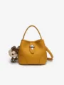 Stylish yellow leather bucket bag with top handle and cute plush bear charm for women. - Pumpkin Yellow