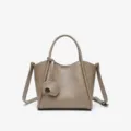 Elegant taupe leather tote bag with top handles and adorable elephant charm for daily wear. - Khaki